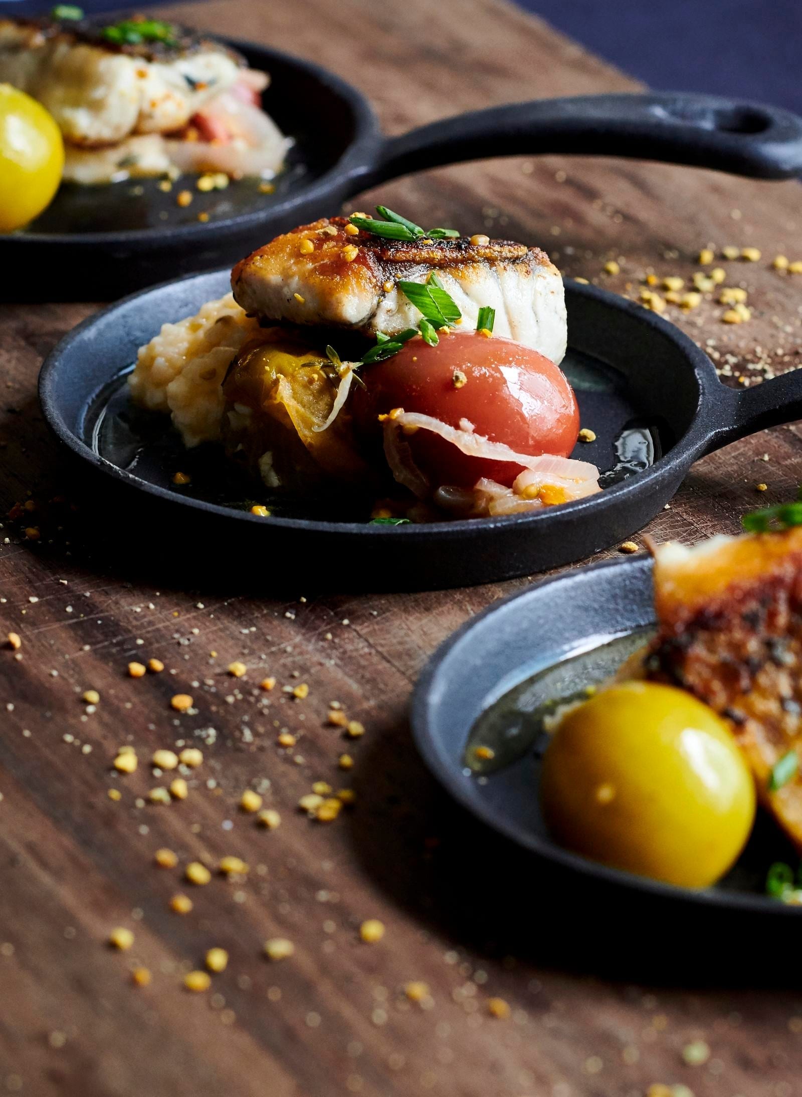 Crispy Skin Barramundi with Cheddar Grits, Braised Tomatoes and Bee Pollen Vinaigrette